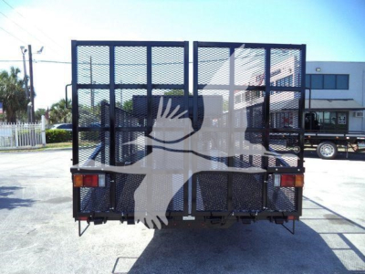 Truck bed rear view with metal mesh gate and taillights; Isuzu NPR Series landscape truck in a parking lot.