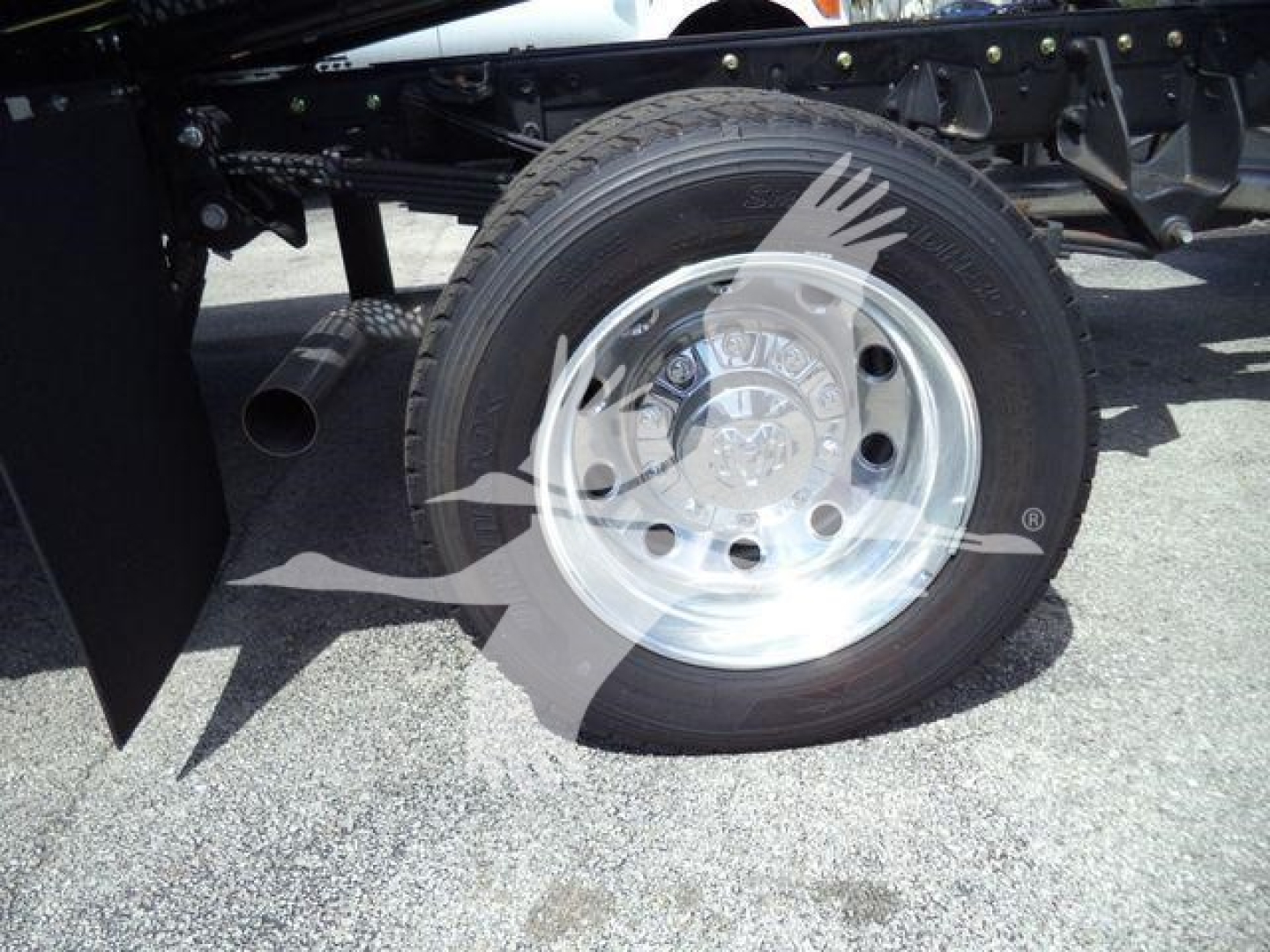 Ram 5500 axle area showing chrome wheel and tire with truck frame and exhaust pipe visible
