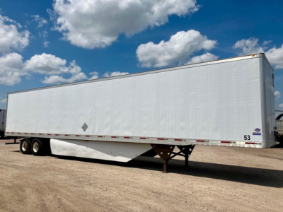 Utility van trailer showing white rectangular cargo box with tandem axles and landing gear, under a blue sky with clouds.