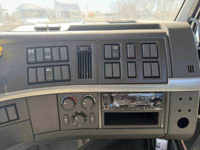 Dashboard of a Volvo VHD86B300 cab and chassis showing control panels, HVAC knobs, empty radio slot, and various switches.