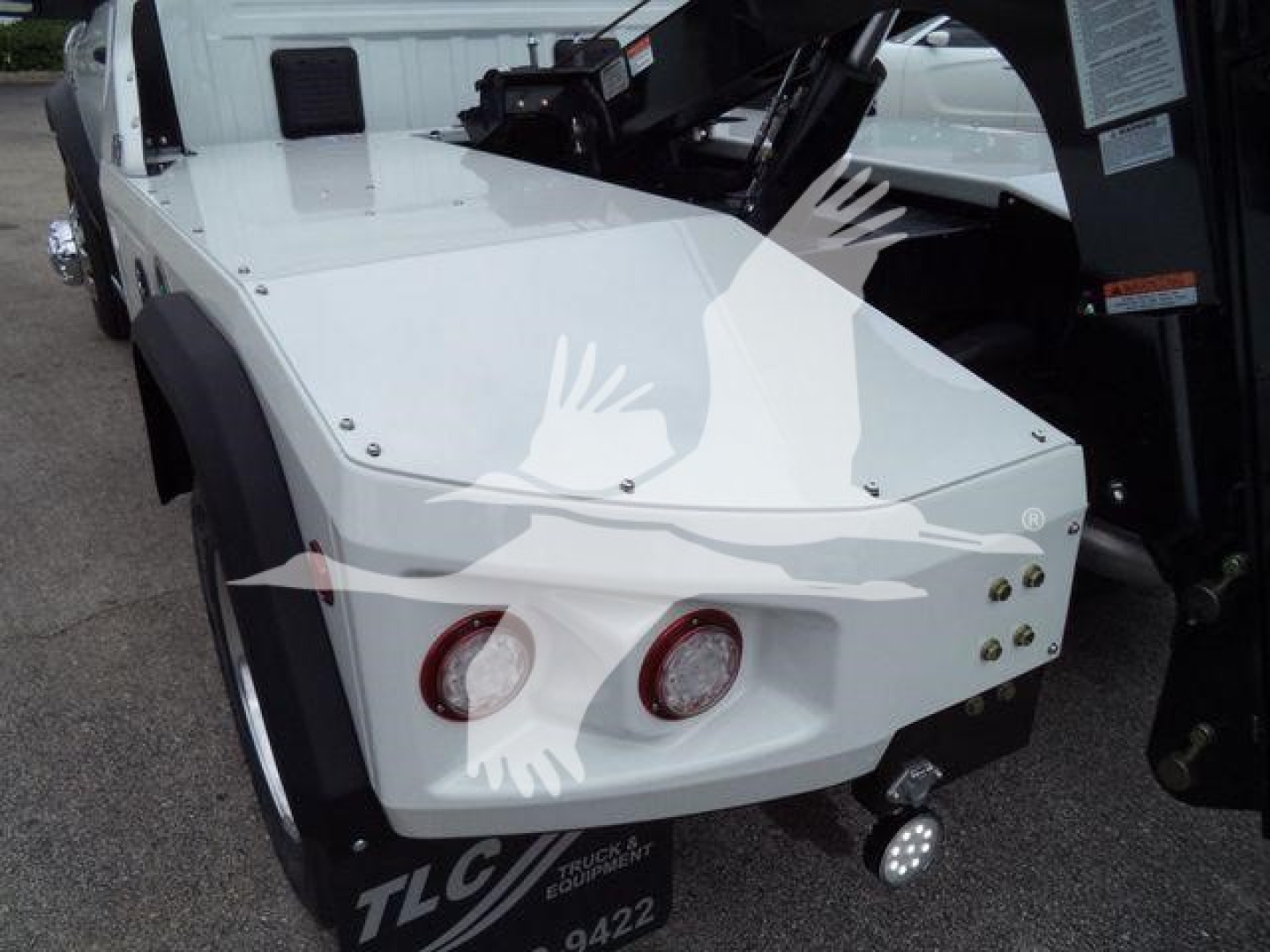 Front left view of a white Ram 4500 SLT with a winch system mounted; visible fender, dual round headlights, and bumper with mounting hardware.