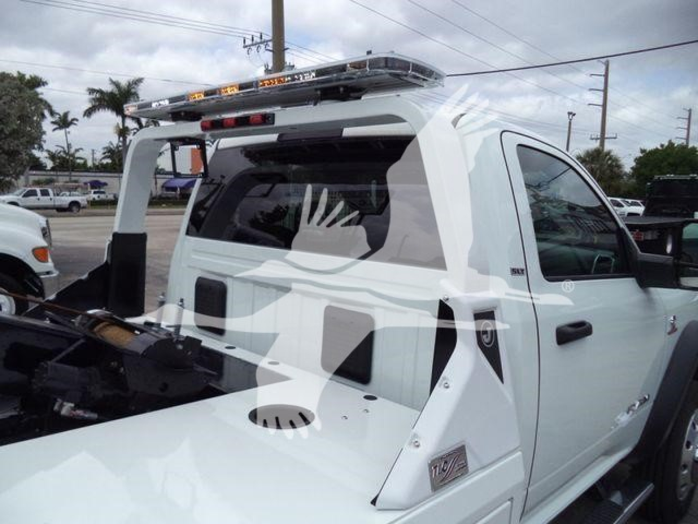 Ram truck with winch setup showing rear bed area and racks; visible text on side panel reads RAM and badge; equipment on bed.