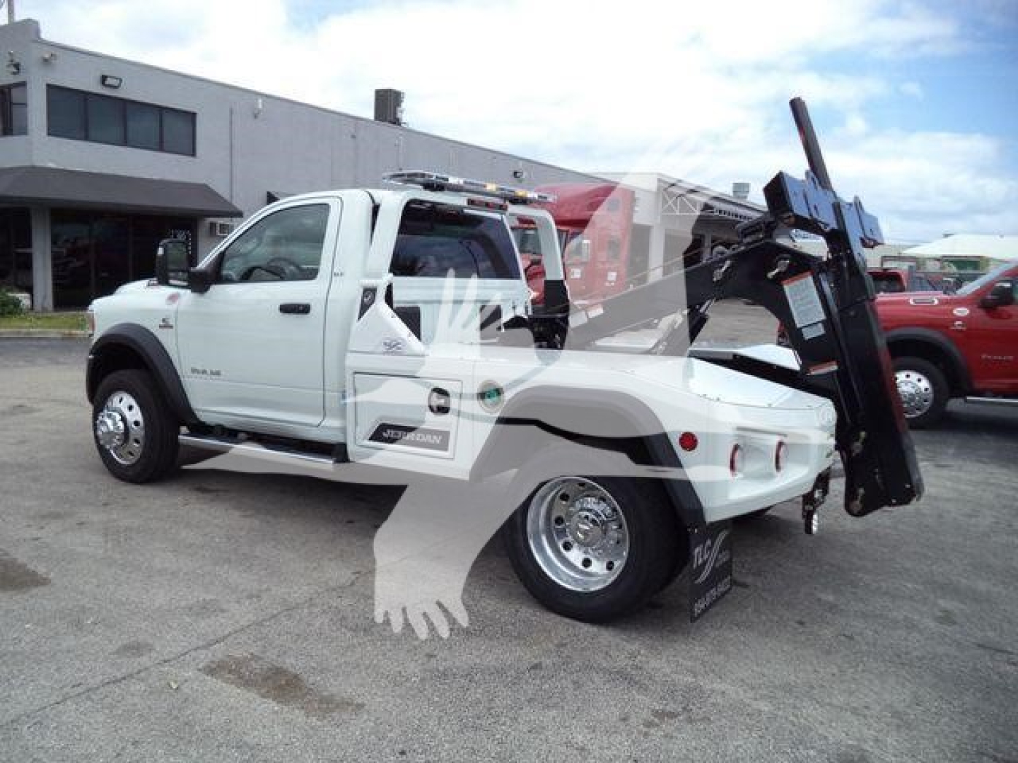 Ram 4500 tow truck with crane in white showing wheel, cab, and bed with hydraulic lift.