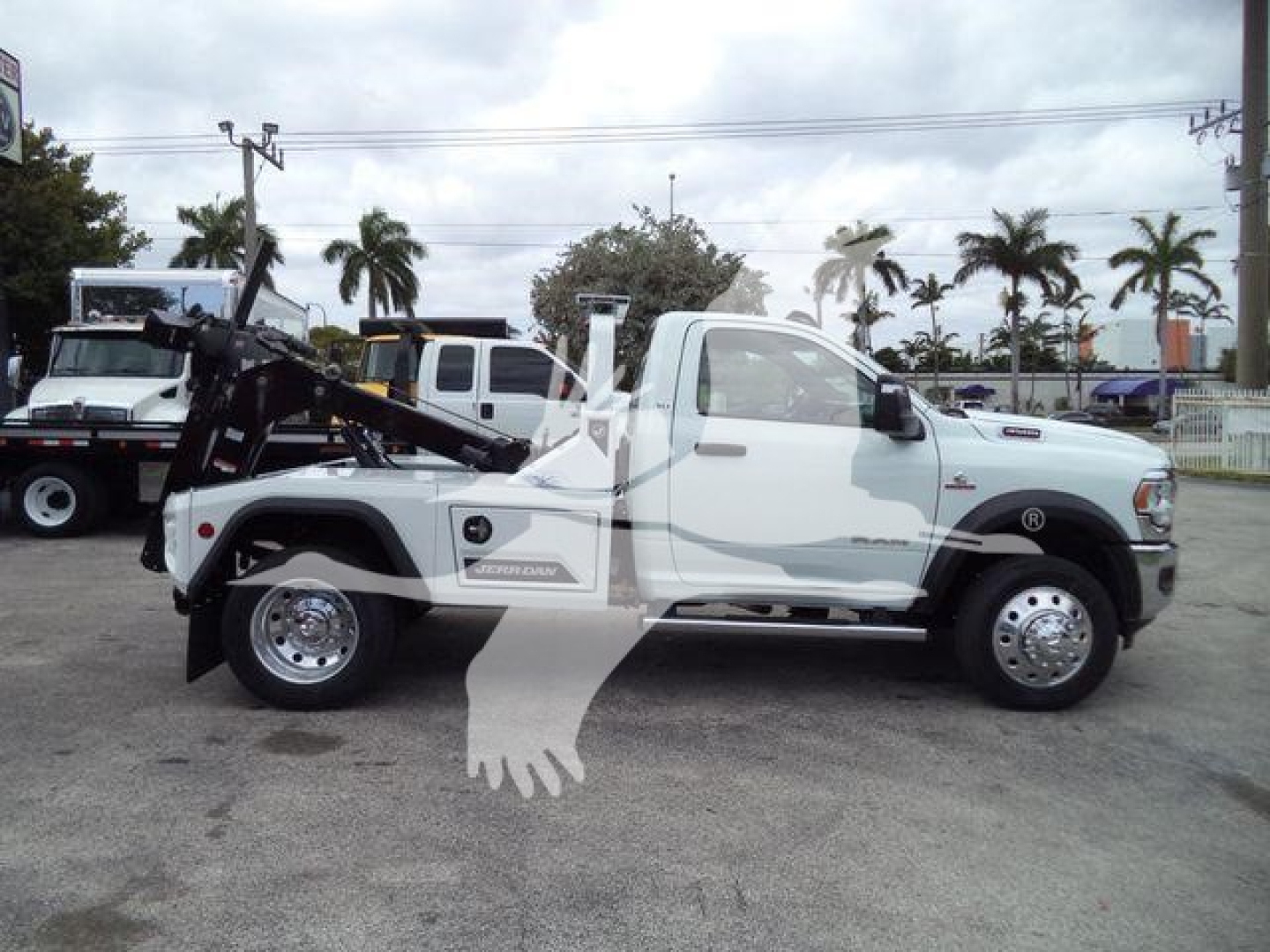 Ram 4500 Tow Truck side view showing winch equipment and white cab, with decals and wheel rims visible.
