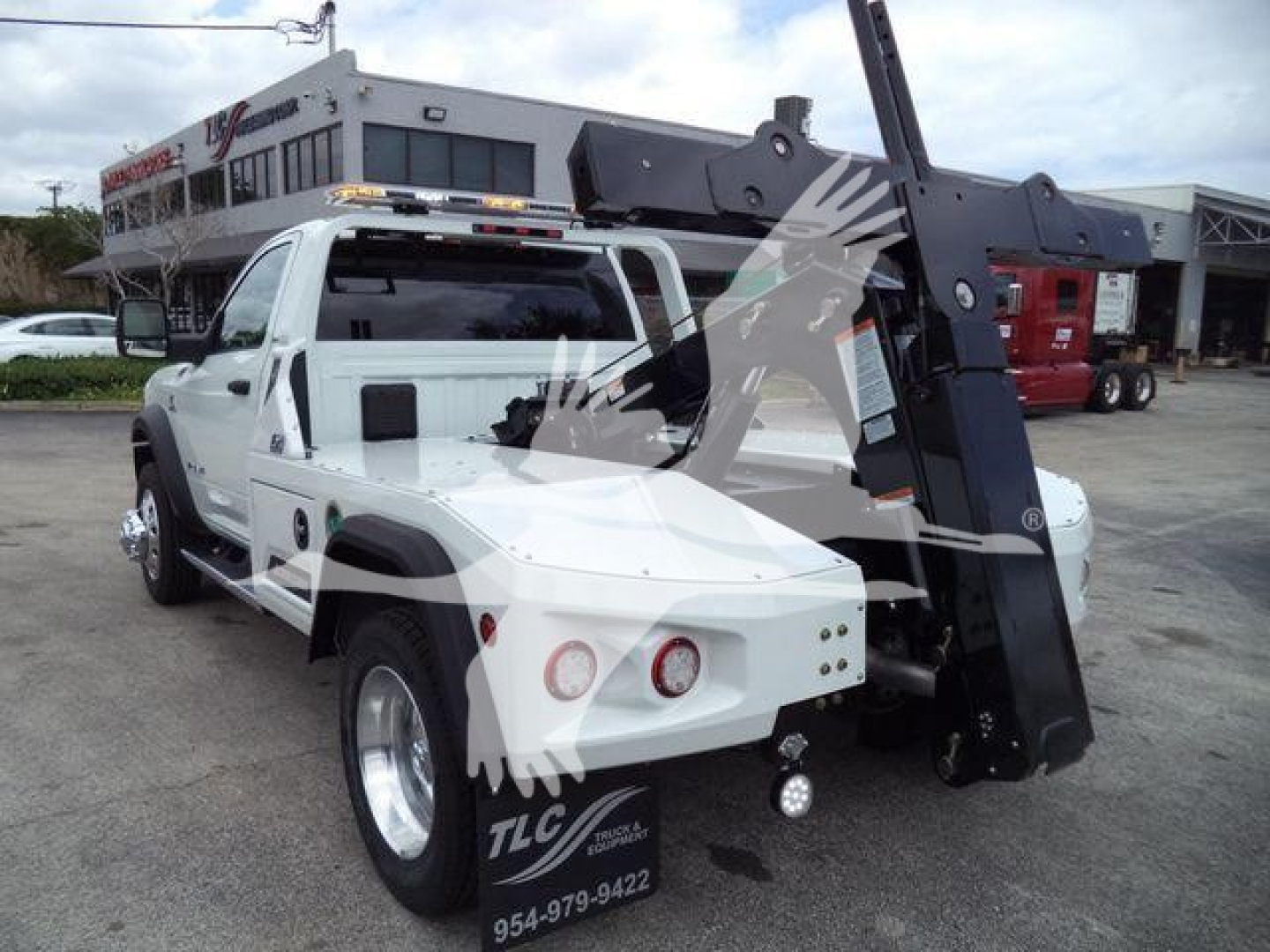 Ram 4500 tow truck with large crane/winch in white, side view showing front and mid-section with winch apparatus and equipment mounting.