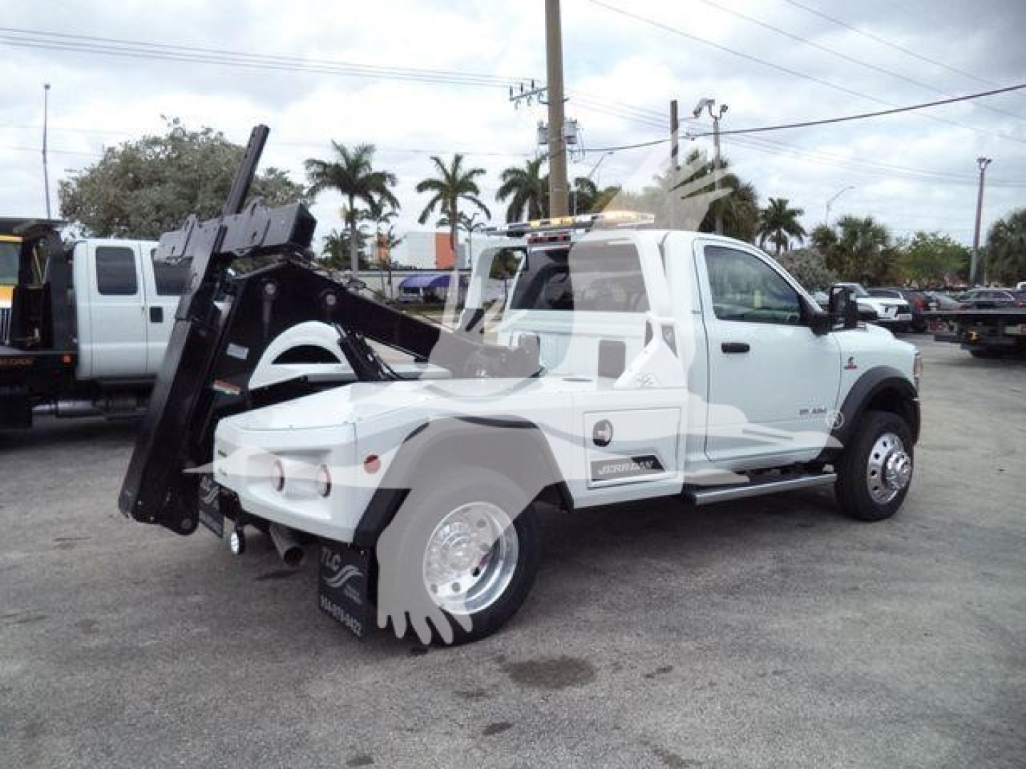 Ram 4500 truck with large white body and winch attachment, rear wheels visible with large chain/wheel assembly.