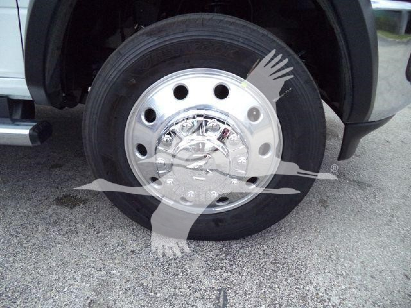 Truck wheel with polished steel hubcap and exposed lug nuts in a Ram 4500 listing image.