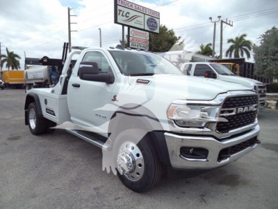 Ram 4500 SLT tow truck/flatbed with white cab showing side mirror duals and chrome wheels.