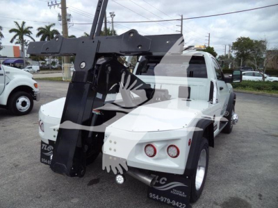 Ram 4500 SLT pickup truck with a large black winch mount and grapple attached in a service lot, white body, two rear red lights.