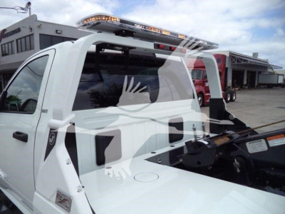 Ram 4500 SLT pickup with a winch setup in service bay; rear cab with roof-mounted light bar and winch apparatus visible.