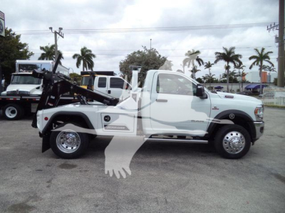 Ram 4500 Tow Truck side view showing winch equipment and white cab, with decals and wheel rims visible.
