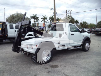 Ram 4500 truck with large white body and winch attachment, rear wheels visible with large chain/wheel assembly.