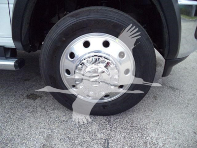 Truck wheel with polished steel hubcap and exposed lug nuts in a Ram 4500 listing image.