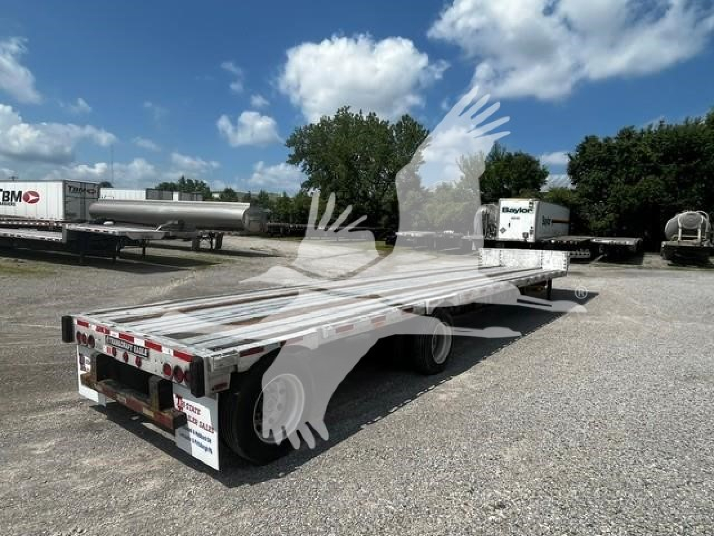 Transcraft DTl-2000 drop deck trailer showing flatbed with dual rear axles and rear lights.