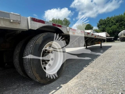 Dual rear axles of a Transcraft trailer showing tires and underside; no legible model text visible on components in this angle.