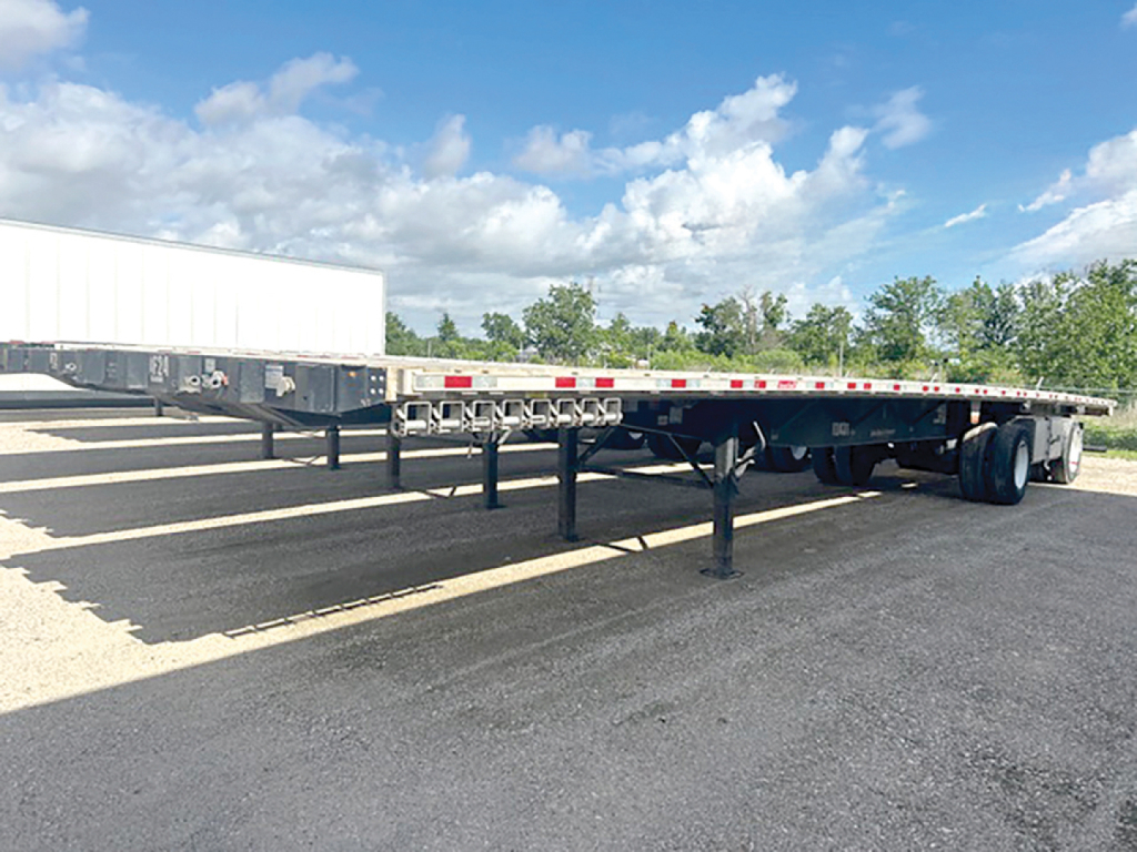 Flatbed trailer showing axles and undercarriage with RH602481 VIN and stock 553045 visible