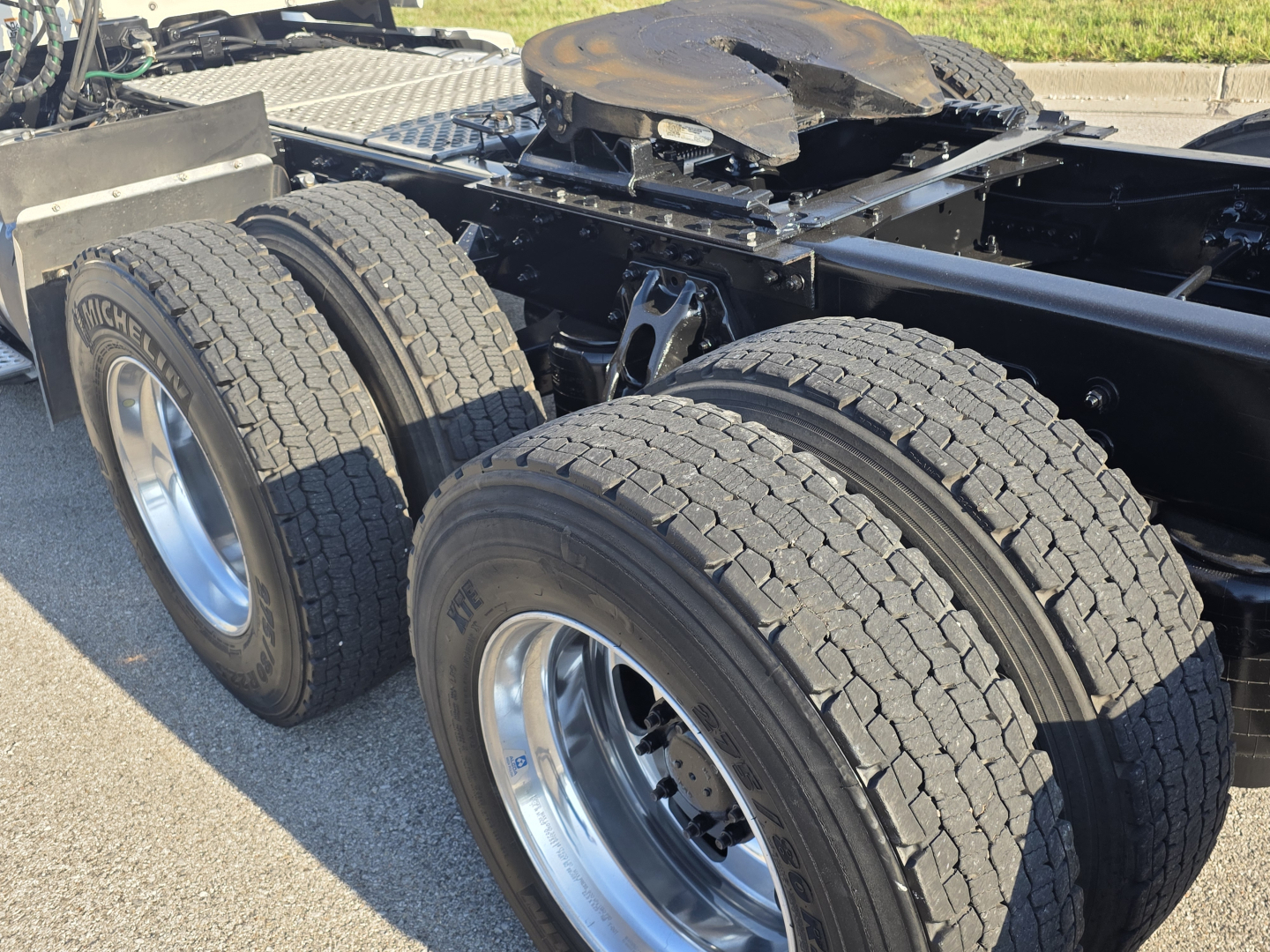 Kenworth T680 chassis with dual rear axles and tires visible, showing wheel rims and framing.