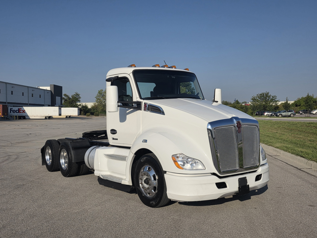 Kenworth T680 conventionally designed truck showing front grille and cab with white paint and dual rear wheels.
