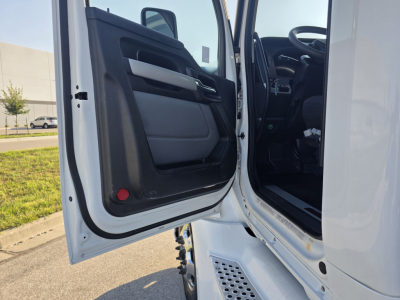 Kenworth T680 truck door open showing interior cabin with black and gray door panel, steps, and part of dashboard.