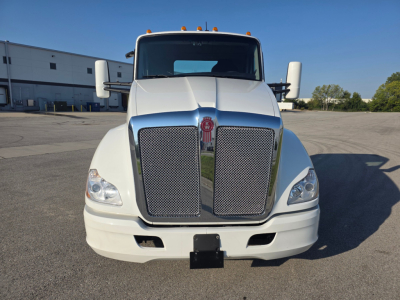 Kenworth T680 front view showing large mesh grille, dual headlights, white cab, side mirrors, and bumper.