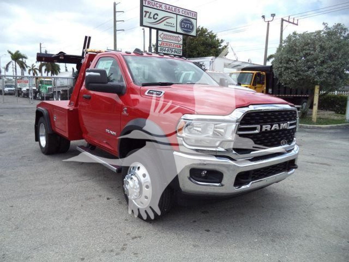 Ram 4500 pickup truck in a dealership lot, front-left view, red with gray graphic accents, chrome grille, large tires, winch setup visible at rear bed.