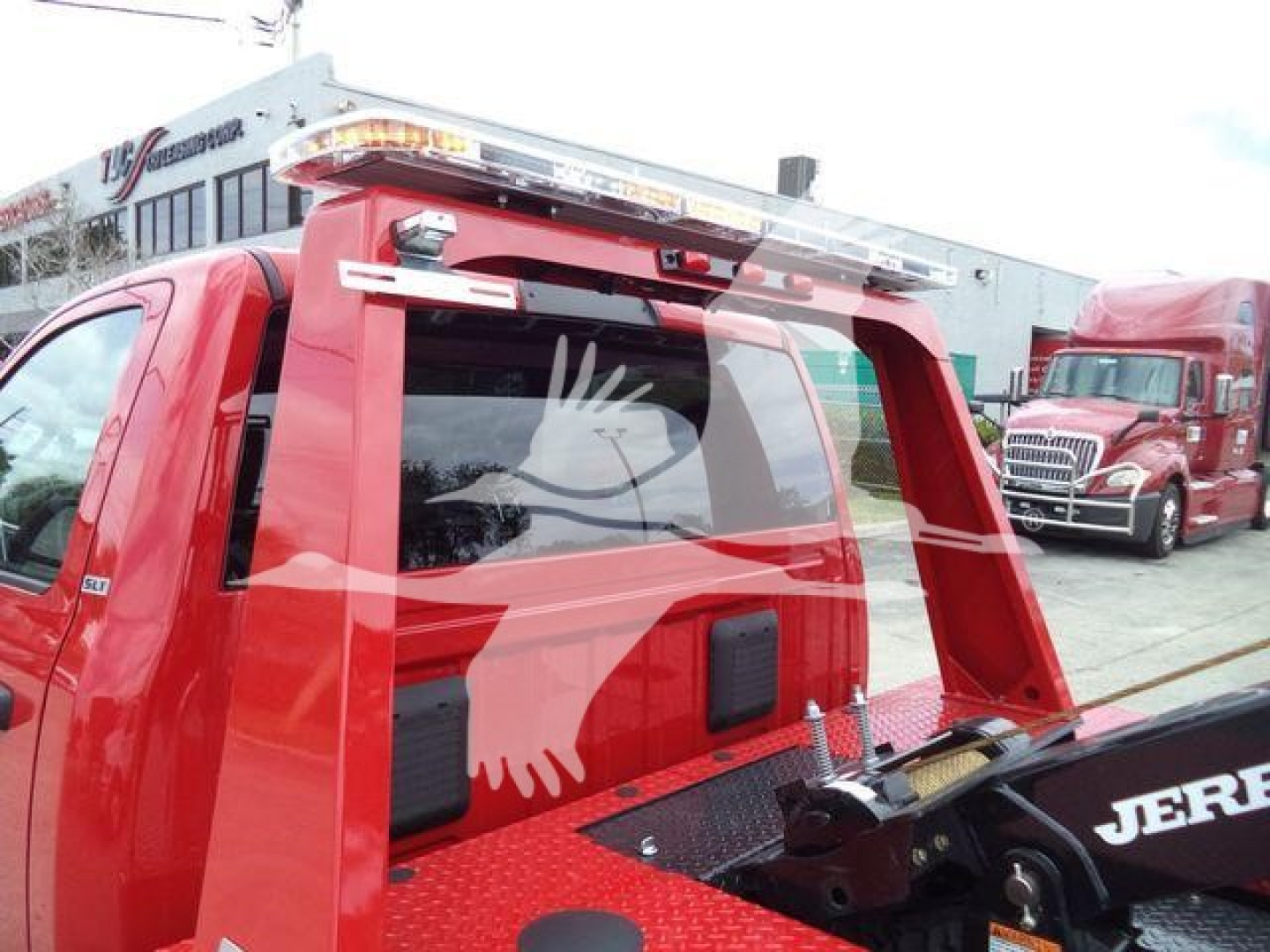 Ram 4500 SLT winch-equipped truck showing rear view with red metal bed and hydraulic winch arm; stock number J82921FM visible on building in background.