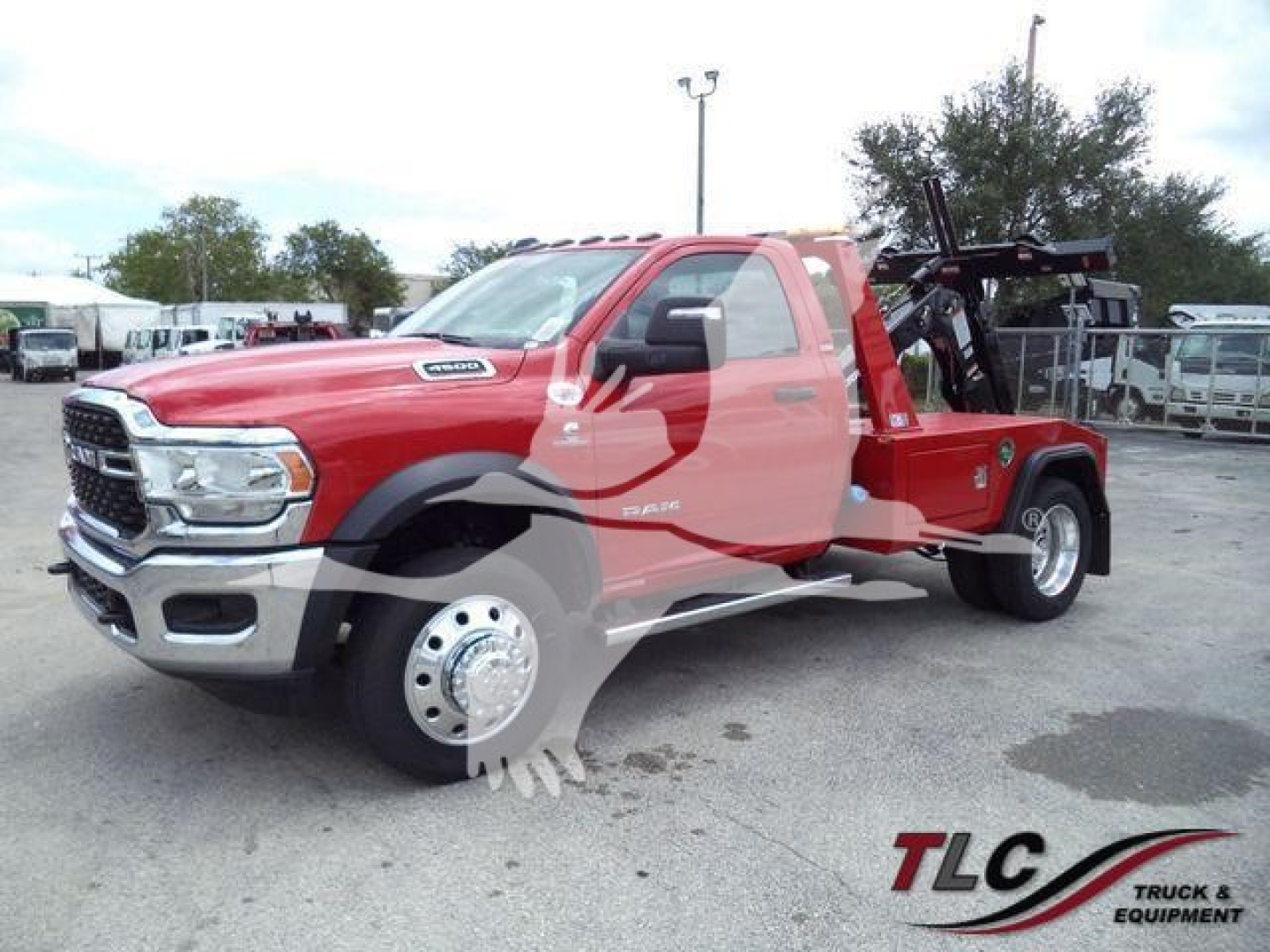 Ram 4500 tow truck/flatbed with red cab showing front and passenger side, winch equipment in bed, stock image.
