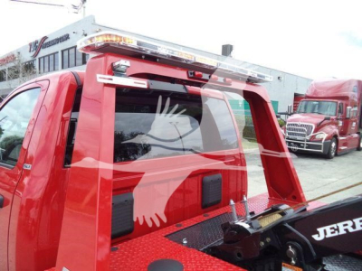 Ram 4500 SLT winch-equipped truck showing rear view with red metal bed and hydraulic winch arm; stock number J82921FM visible on building in background.