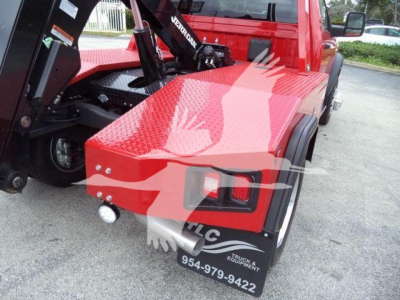 Ram 4500 truck bed with winch and Diamond plate deck, rear view showing taillights and a tow hitch.