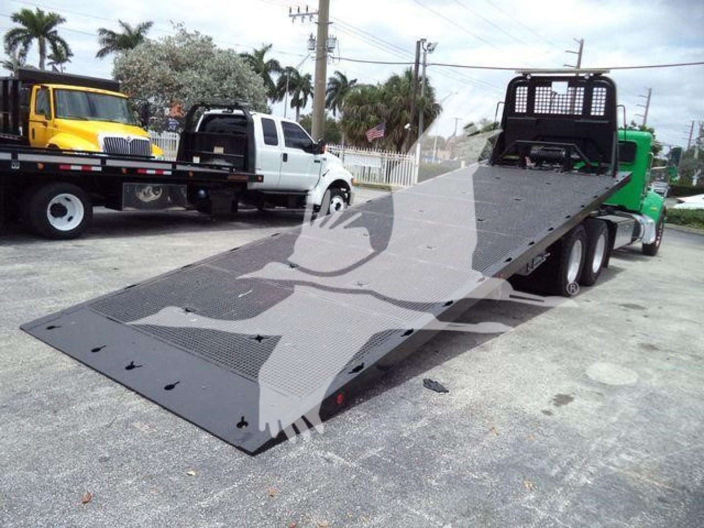 2016 Peterbilt 348 rollback tow truck with flatbed low-profile loading ramp showing heavy-duty steel bed and wheel tires