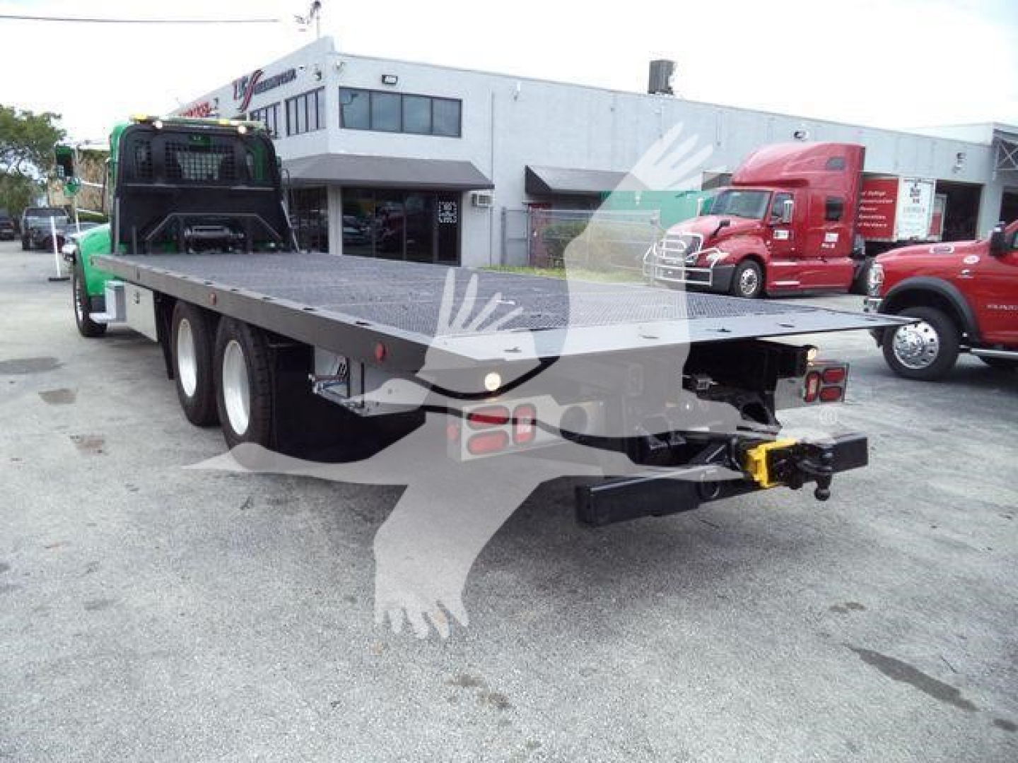 Peterbilt 348 rollback truck trailer with flatbed, rear view showing hitch and undercarriage components.