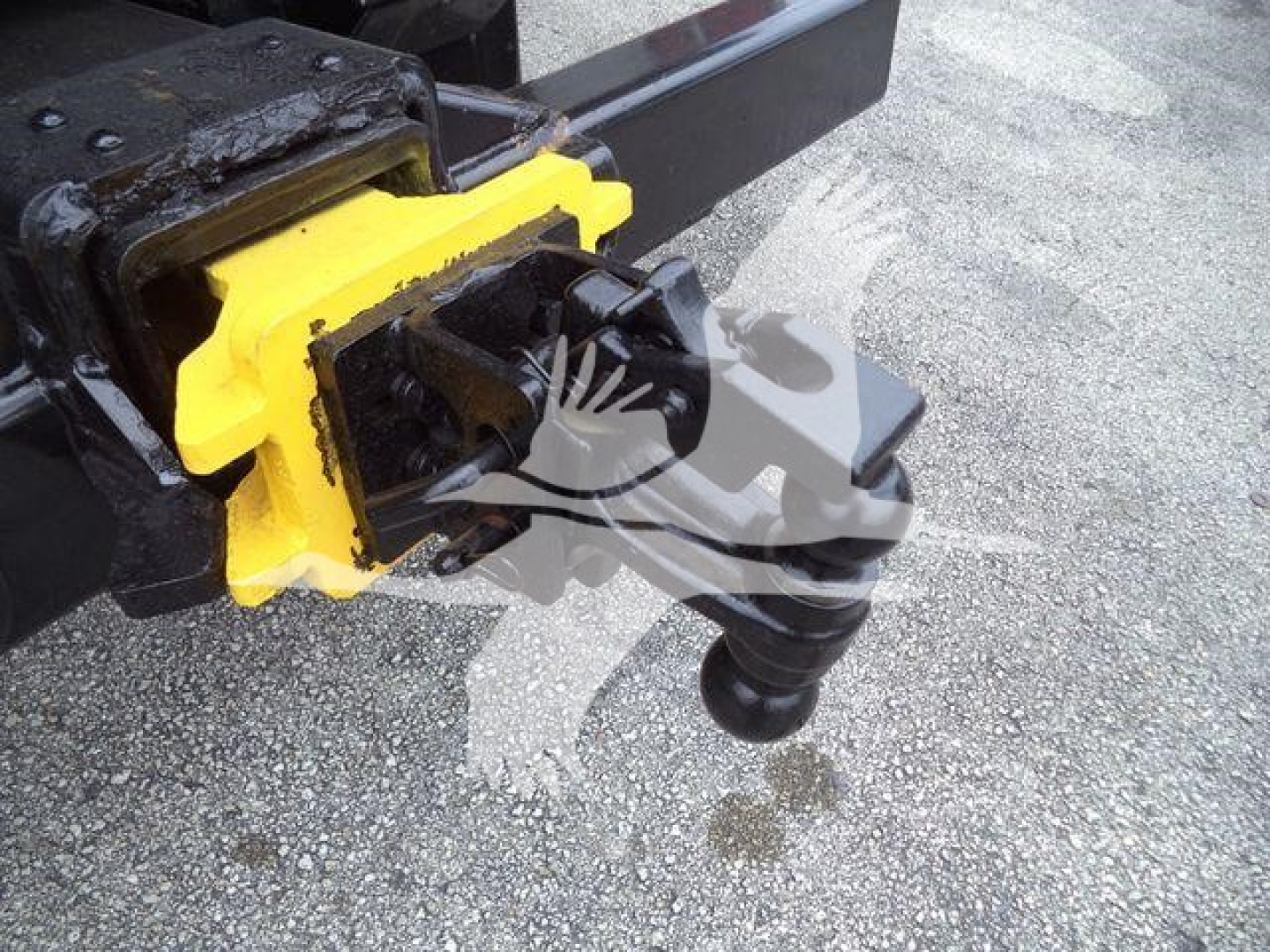 Trailer hitch with yellow coupler and black flexible kingpin/air hoses attached.