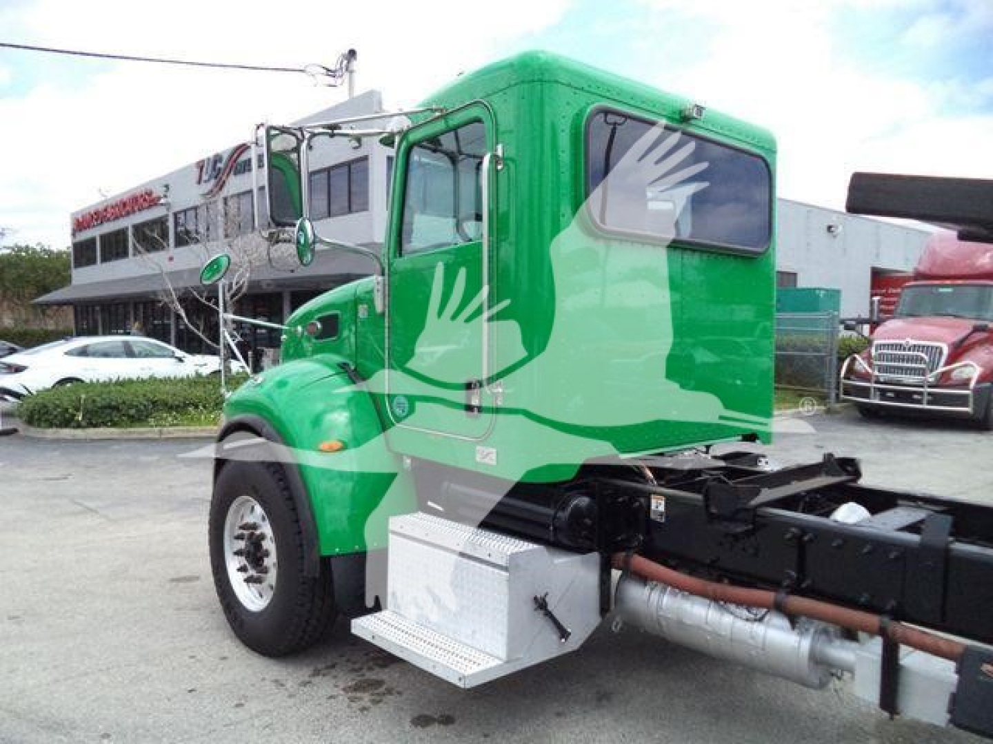 Peterbilt 348 rollback truck in green color, front-left view, with side steps and tank visible, stock number T40939FM.