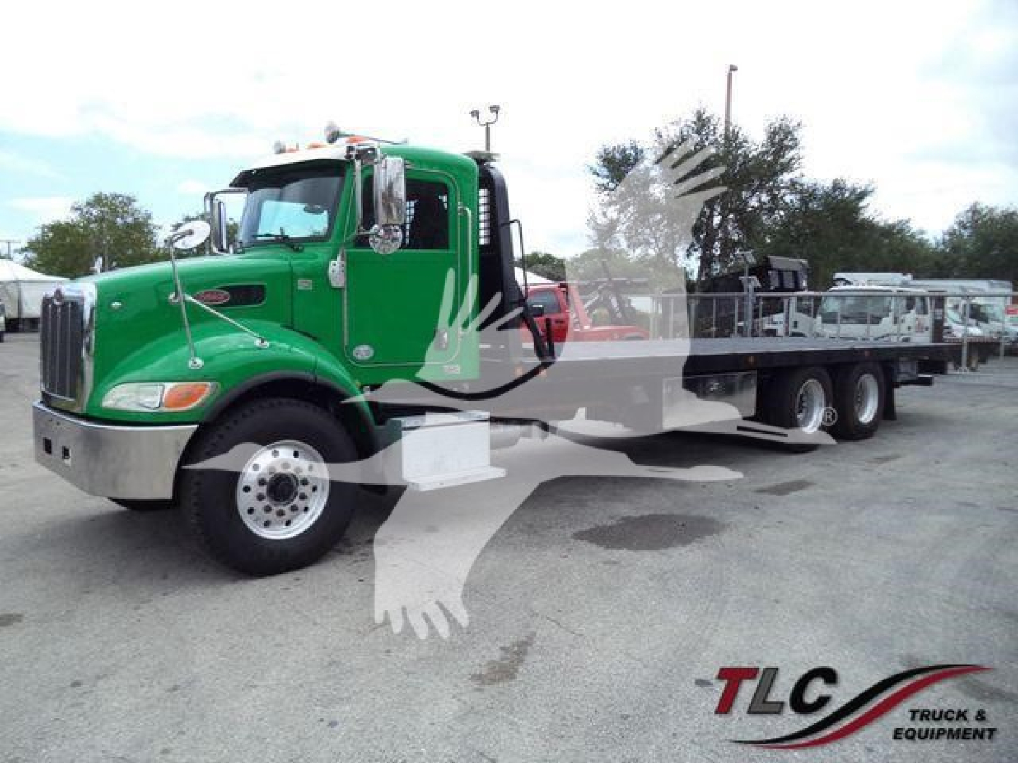 Peterbilt 348 rollback truck in green with flatbed, front grille, dual rear wheels, and side mirrors; TLG watermark and faint background equipment.