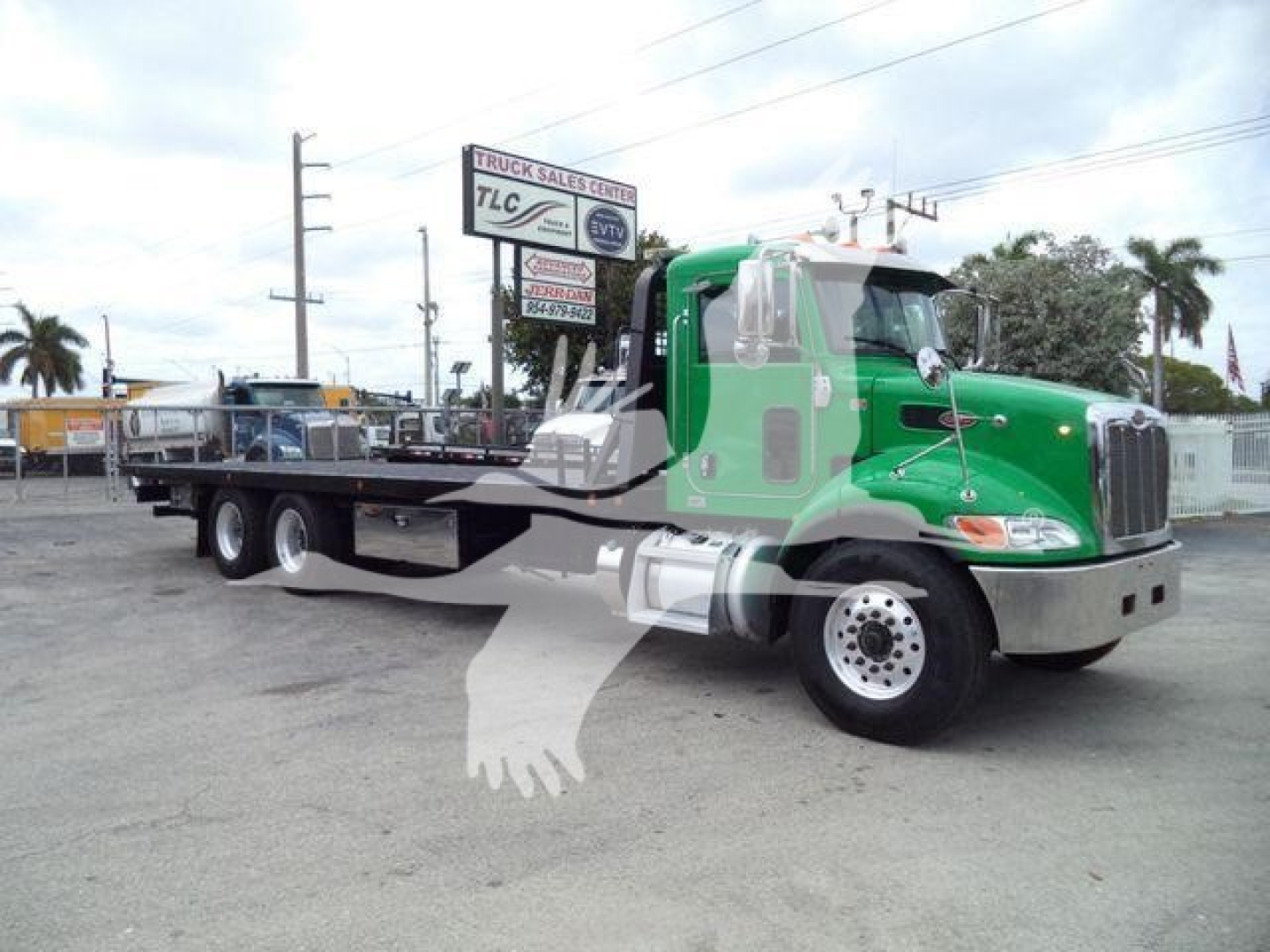 Peterbilt 348 rollback truck in green with flatbed, side view shows cab and dual rear axles. Visible text: no legible serials or logos aside from truck silhouette watermark.