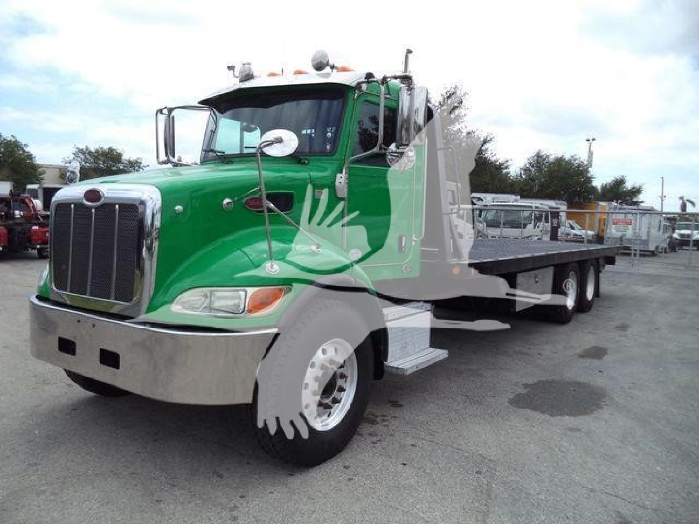 Peterbilt 348 rollback tow truck in green and gray, front cab with chrome bumper, flatbed trailer visible, stock number T40939FM.