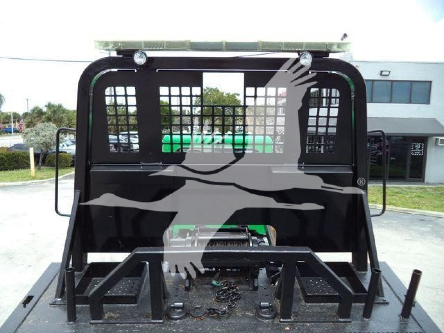 Peterbilt 348 rollback truck cab rear with heavy steel mounting frame and protective mesh grid.