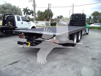 Flatbed tow truck chassis of a 2016 Peterbilt 348 rollback showing rear and flatbed with dual rear axles and towing hitch.