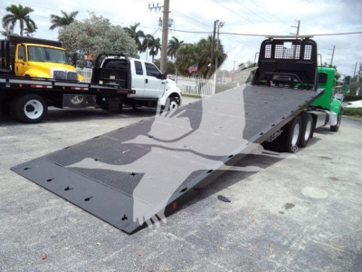 2016 Peterbilt 348 rollback tow truck with flatbed low-profile loading ramp showing heavy-duty steel bed and wheel tires