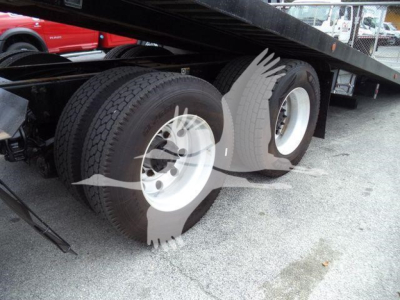 Rear dual-axle truck wheels under a rollback bed; no legible model text visible.