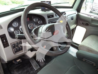Peterbilt 348 cab interior showing steering wheel, dashboard gauges, and driver seat.
