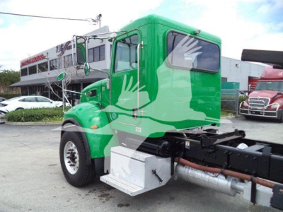 Peterbilt 348 rollback truck in green color, front-left view, with side steps and tank visible, stock number T40939FM.