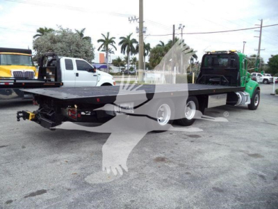 Peterbilt 348 rollback truck flatbed with dual rear axles and a green day cab, shown from rear-left side.