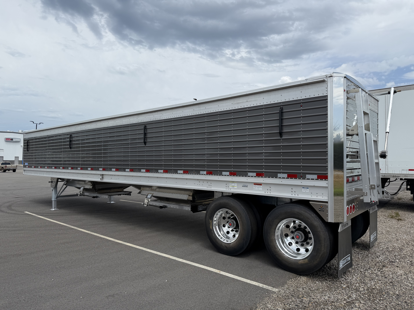 Stoughton 40' alum grain hopper trailer with 68in corrugated sidewalls, side paneling, dual rear axles, and front gooseneck area.
