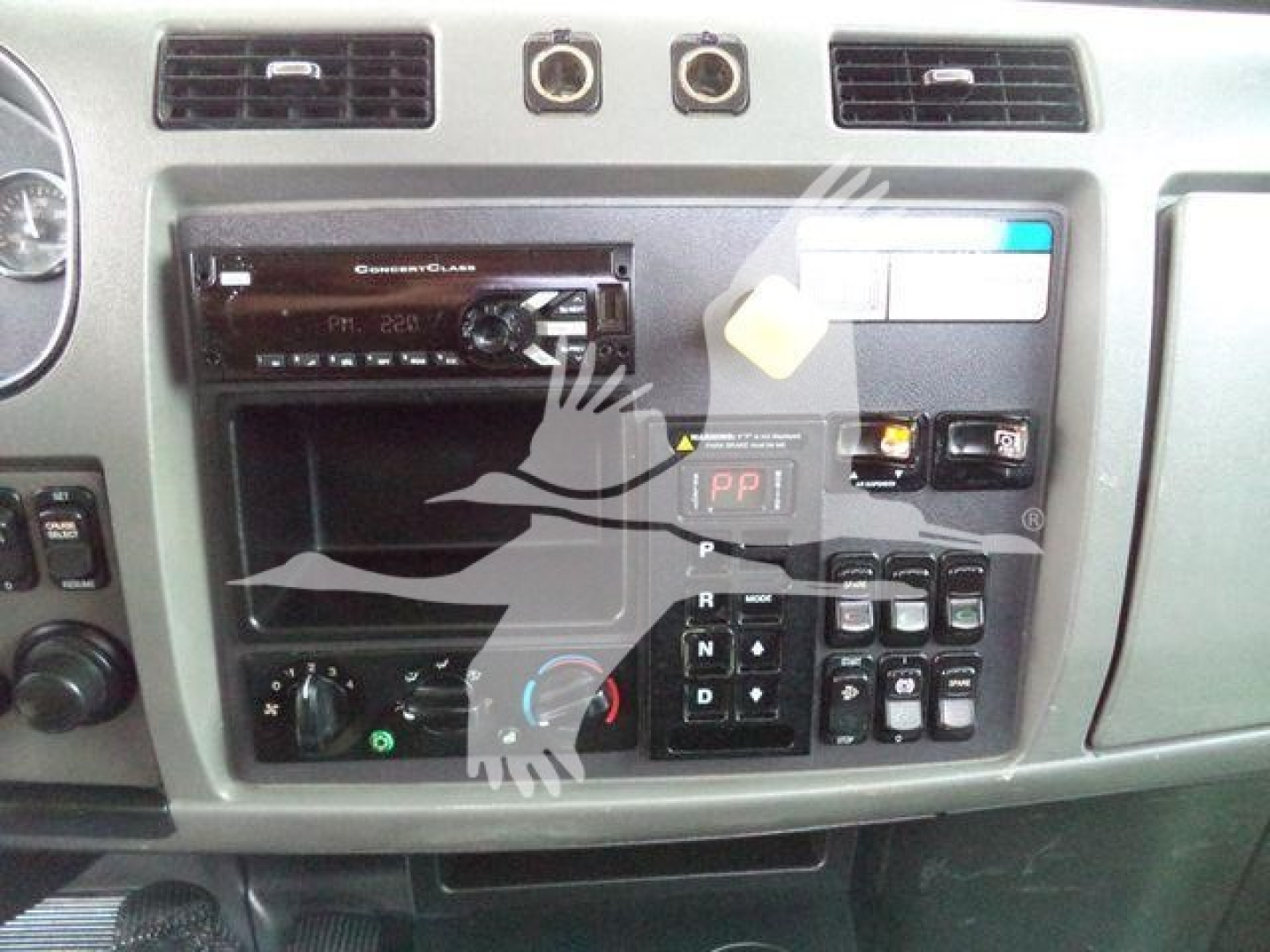 Dashboard of a 2018 Peterbilt 337 rollback truck showing an in-dash stereo unit, control panel, and various switches.
