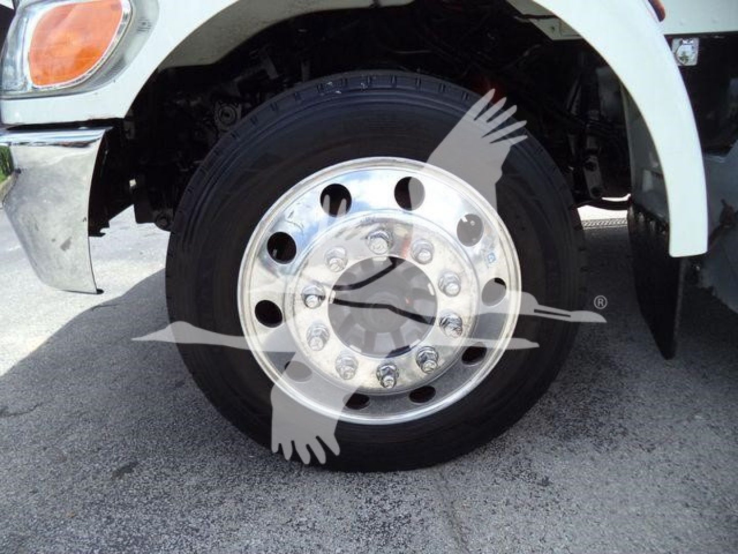 Truck wheel close-up with polished aluminum hub and lug nuts.