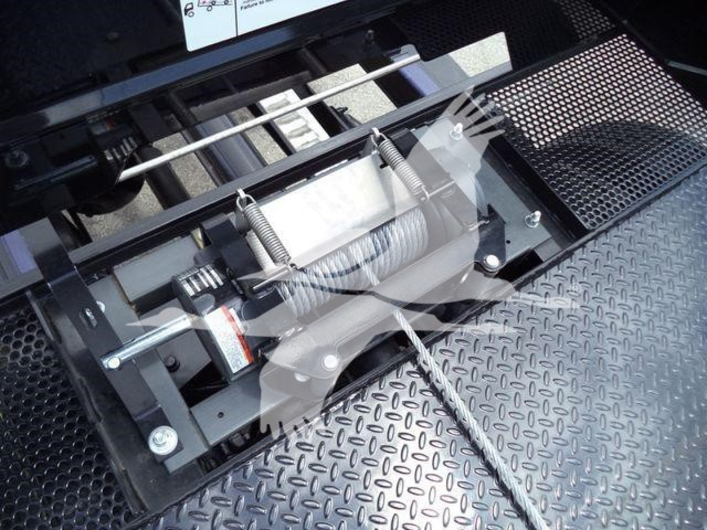 Trailer winch and steel plate shown in truck bed with drill-style winch and cable mechanism (Peterbilt 337).