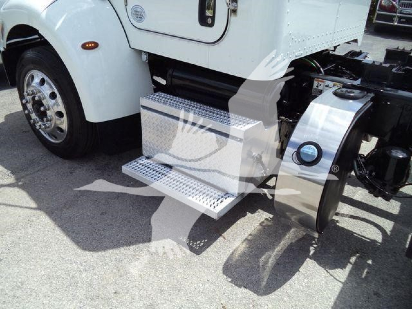 Peterbilt 337 cab forward truck with chrome diamond-plate side step and fuel tank, partial front wheel, view of entry door area