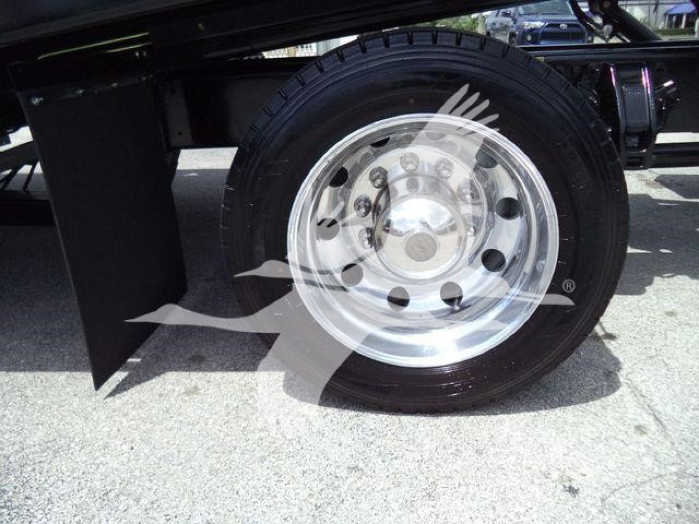 Peterbilt 337 rollback truck wheel close-up showing steel polished rim and tire, part of undercarriage visible.