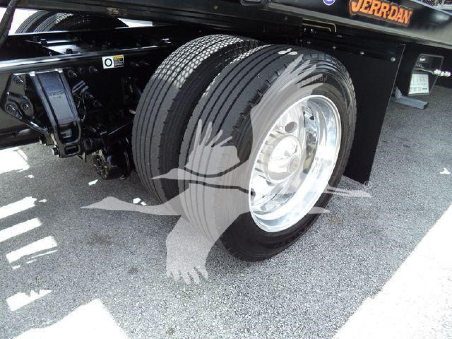 Peterbilt 337 rollback truck wheel and front suspension showing dual rear wheels and front axle; tire tread and chrome wheel visible.